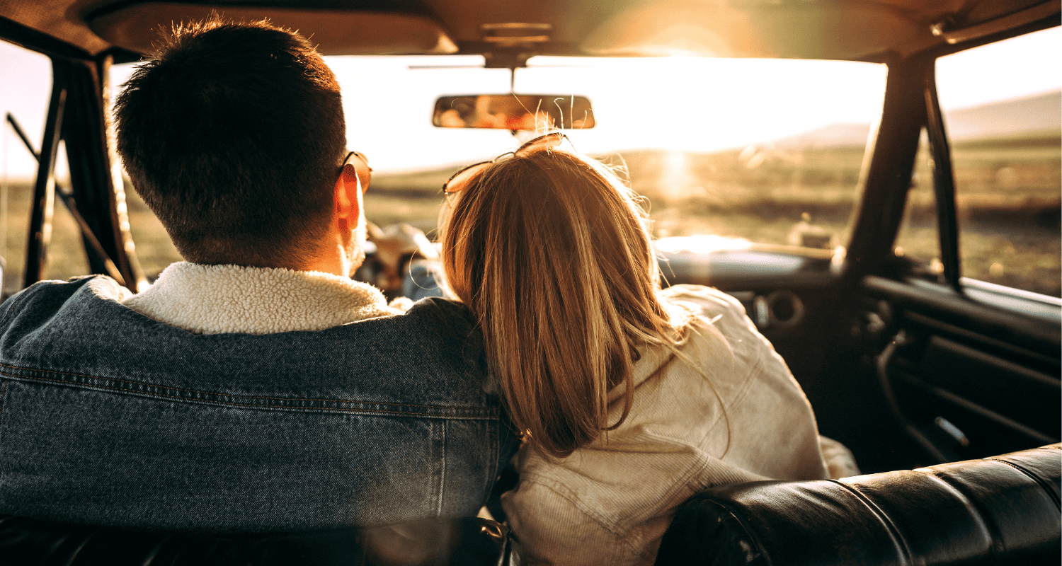 Couple in a car enjoying a scenic drive at sunset in Montenegro.